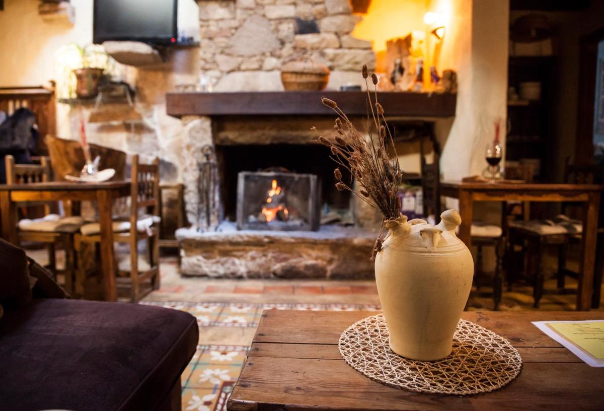 Un jarrón sobre una mesa en una sala de estar con chimenea. en Orgullo Rural, en Bermellar