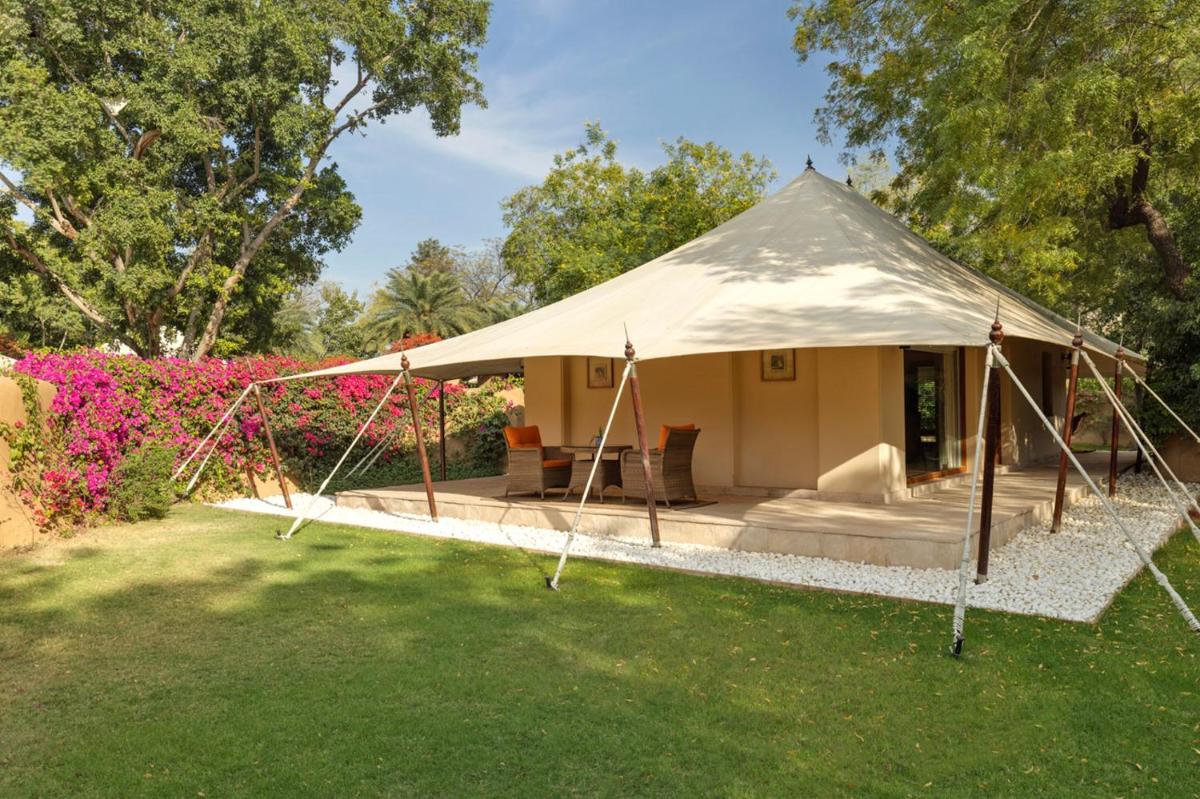 a canvas tent in a yard with flowers at The Oberoi Rajvilas Jaipur in Jaipur