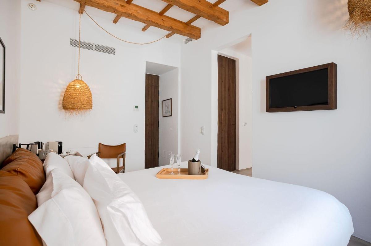 Una sala de estar con una cama blanca y un sofá. en Can Araya, en Ciutadella