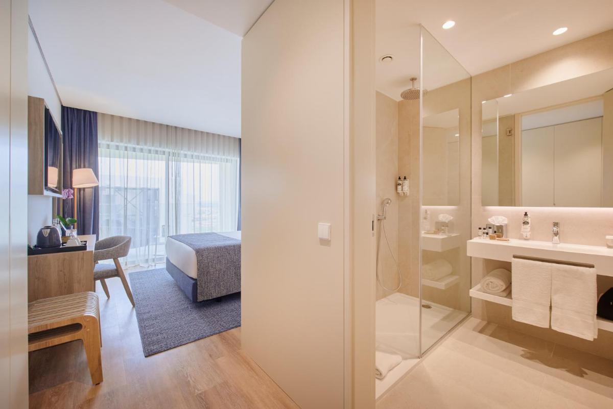 um quarto de hotel com casa de banho com lavatório e chuveiro em The Editory by the Sea Lagos em Lagos
