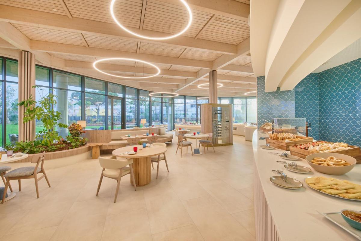 um restaurante com mesas e cadeiras e uma cafetaria em The Editory by the Sea Lagos em Lagos