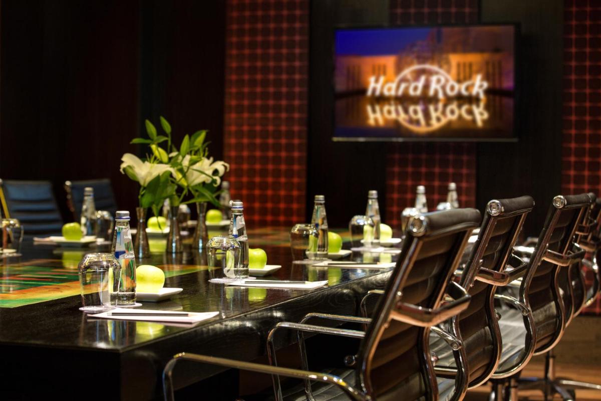 a dining room with a table with chairs and a television at Hard Rock Hotel Goa Calangute in Calangute