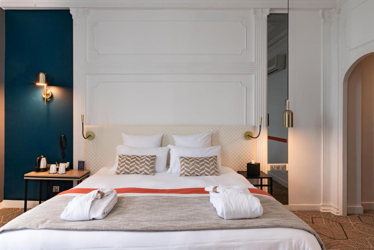 une chambre avec un grand lit et deux serviettes blanches dans l'établissement Oceania Hôtel d'Anjou Angers, à Angers
