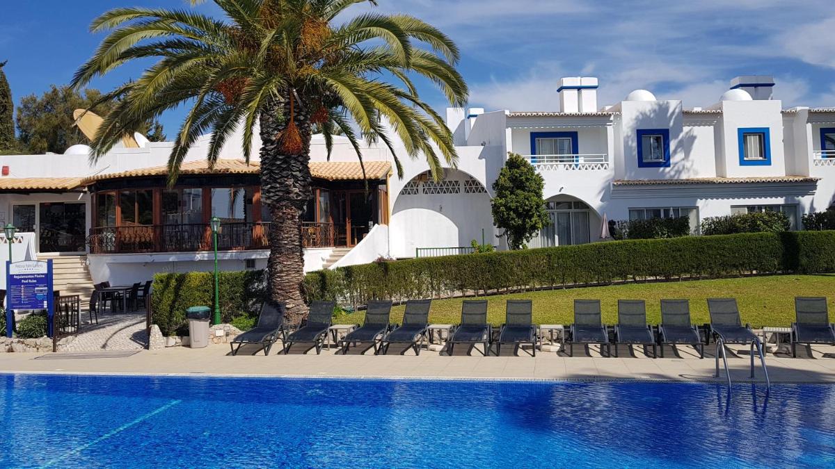 uma casa com uma palmeira e uma piscina em Pestana Palm Gardens em Carvoeiro