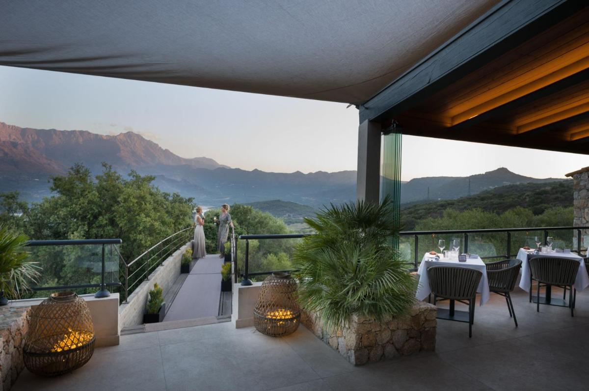 un restaurant avec vue sur les montagnes dans l'établissement Hotel A Piattatella, à Monticello