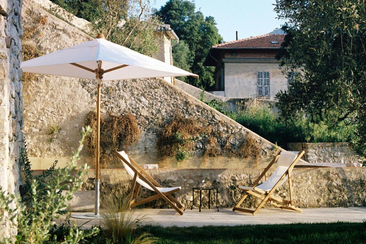 2 chaises et un parasol devant une maison dans l'établissement Hôtel du Couvent, a Luxury Collection Hotel, Nice, à Nice 37 autres photos