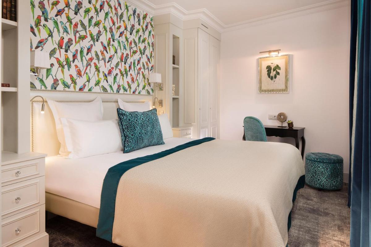 - une chambre avec un grand lit blanc aux accents bleus dans l'établissement Hotel Monge, à Paris