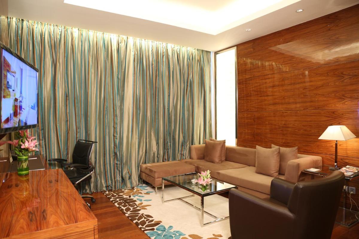 a living room with a couch and a television at Taj City Centre Gurugram in Gurgaon