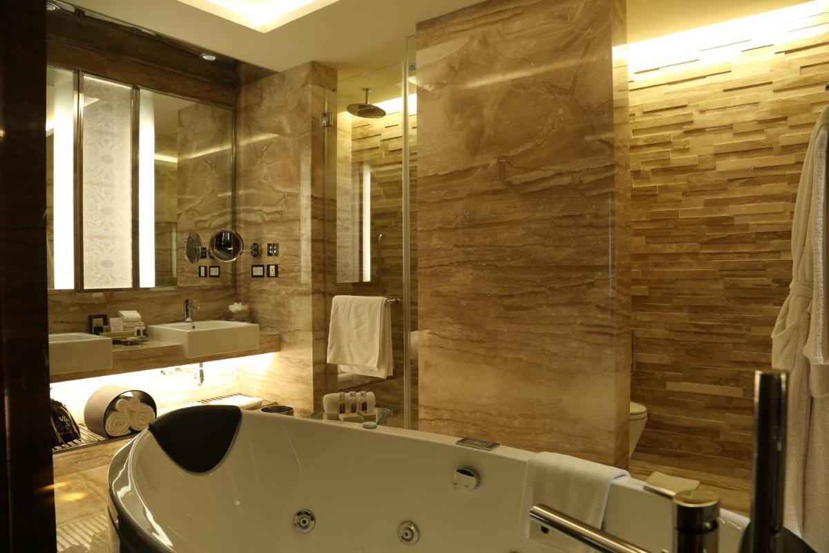 a bathroom with a large tub and a sink at Taj City Centre Gurugram in Gurgaon