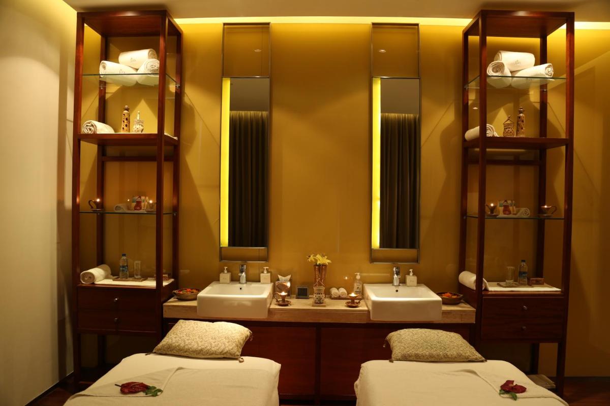 a bathroom with two sinks and two mirrors at Taj City Centre Gurugram in Gurgaon