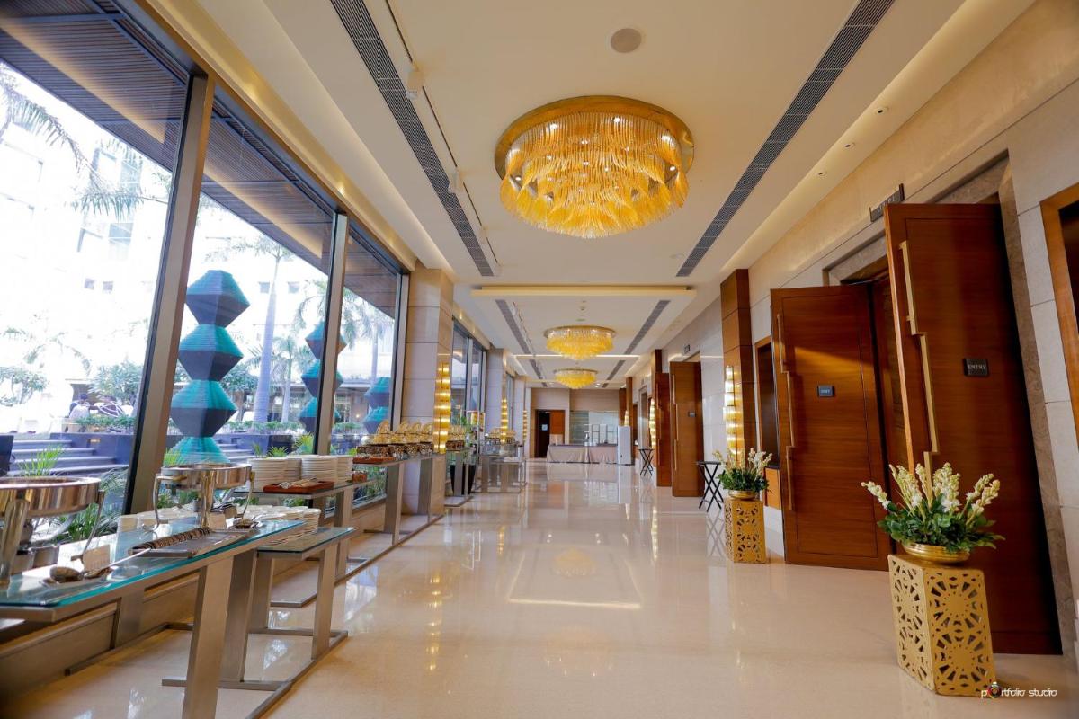 a hallway of a restaurant with tables and windows at Crowne Plaza Today Gurugram by IHG in Gurgaon