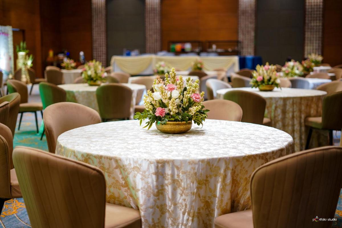 a room with tables and chairs with flowers on them at Crowne Plaza Today Gurugram by IHG in Gurgaon