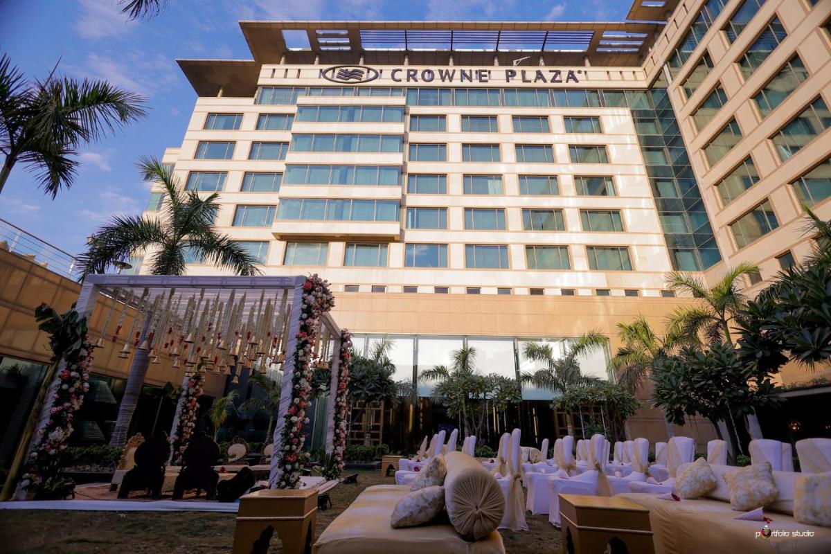 a hotel with white tables and chairs in front of a building at Crowne Plaza Today Gurugram by IHG in Gurgaon