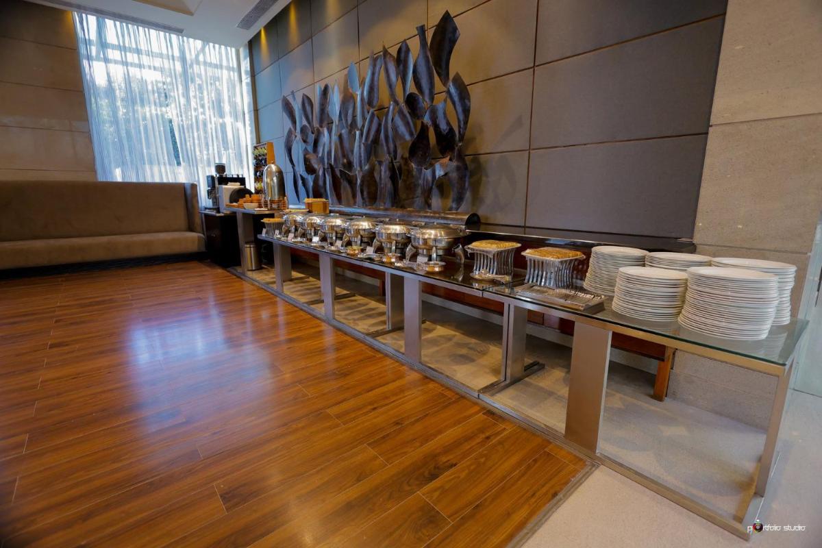 a restaurant with a counter with plates on it at Crowne Plaza Today Gurugram by IHG in Gurgaon