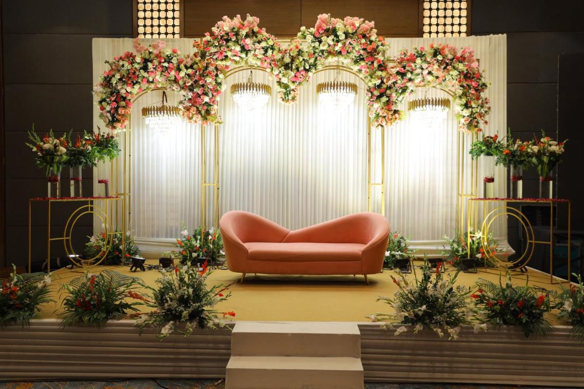 a couch sitting in front of a stage with flowers at Crowne Plaza Today Gurugram by IHG in Gurgaon