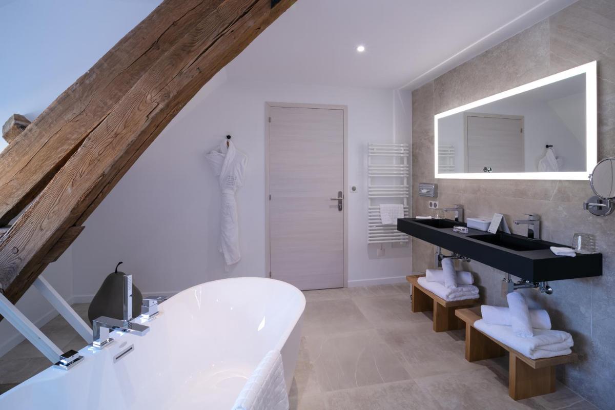 une salle de bain avec une baignoire blanche et un lavabo dans l'établissement Maison Doucet - Relais & Châteaux, à Charolles 36 autres photos