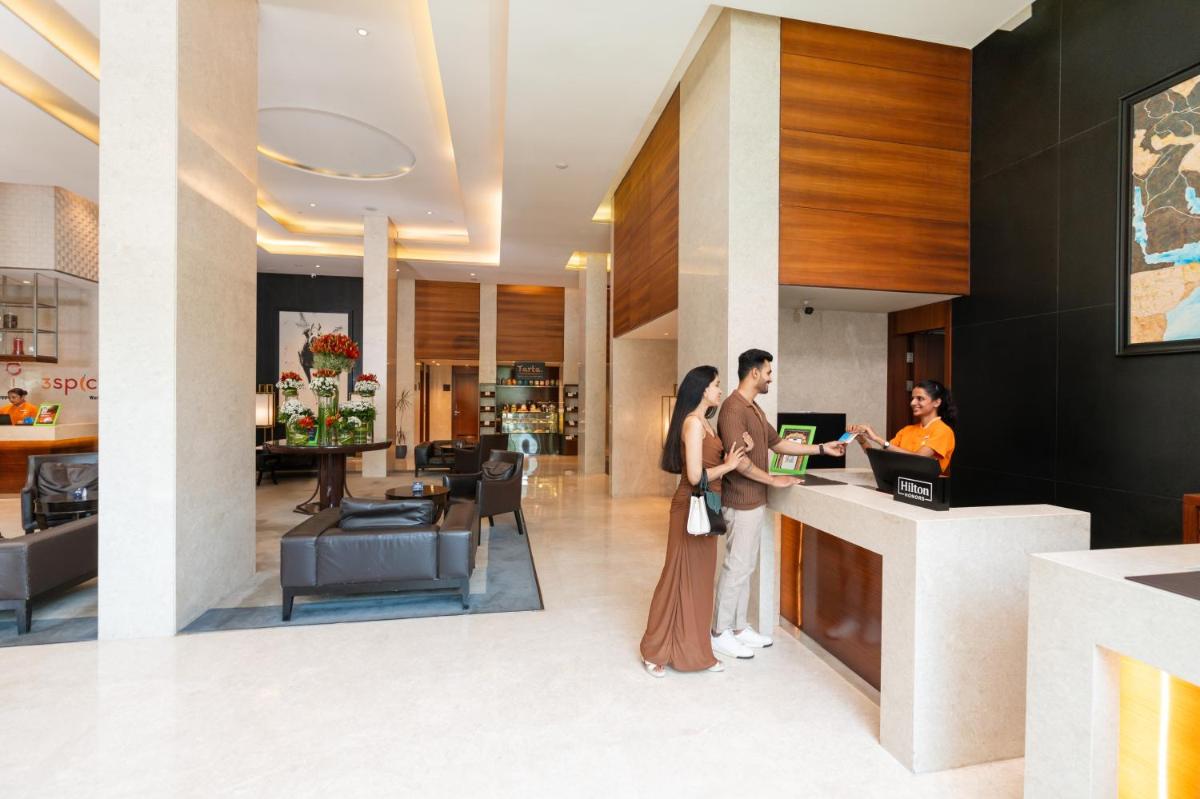 a couple standing at a counter in a hotel lobby at DoubleTree by Hilton-Pune Chinchwad in Pune +89 photos