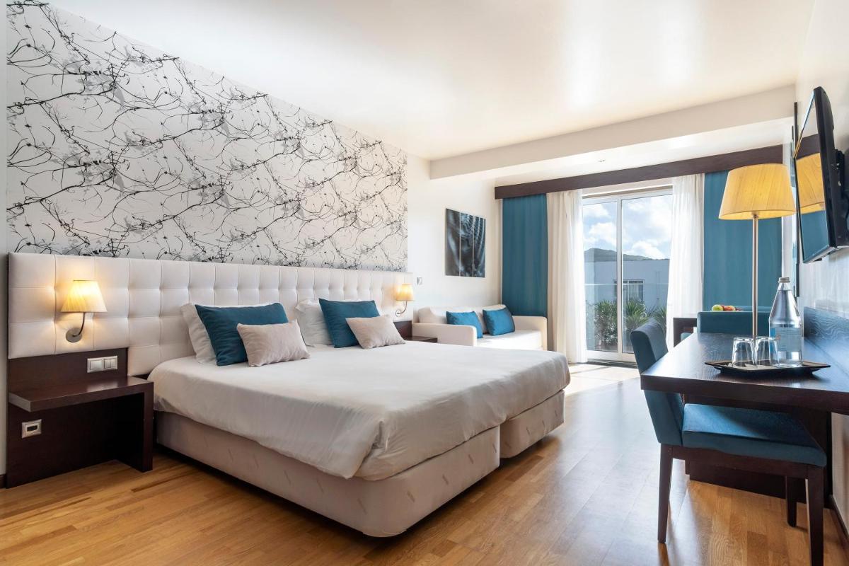 um quarto de hotel com uma cama, uma escrivaninha e um computador em Hotel Vale Do Navio em Capelas