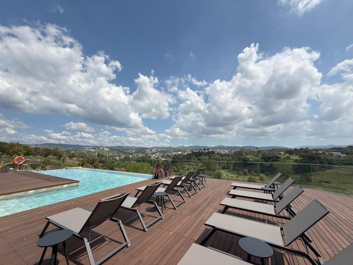 uma fila de cadeiras sentadas num deque ao lado de uma piscina em Haven Nature Hotel & Villas na Batalha