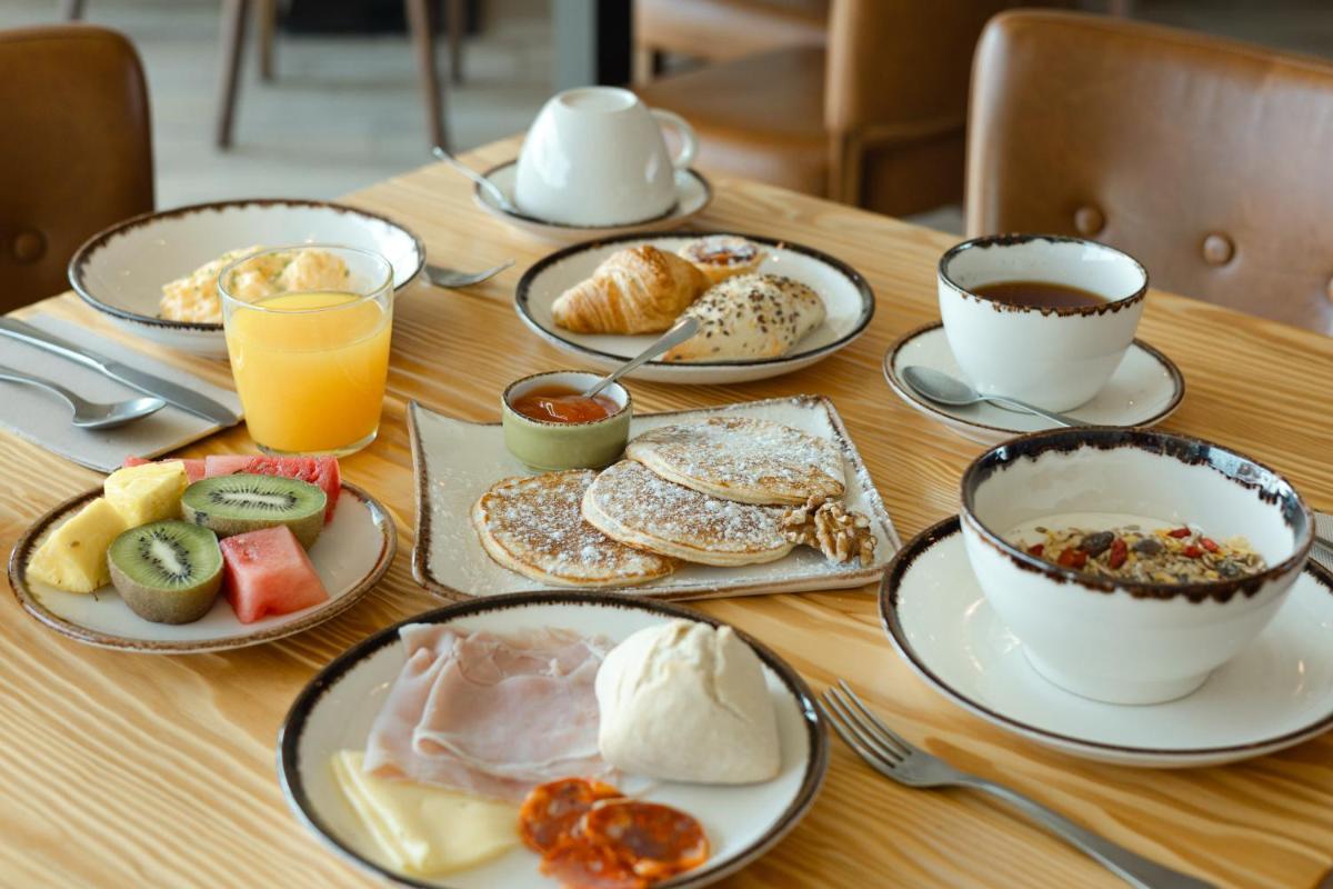 uma mesa coberta com pratos de café da manhã e café em Sleep & Nature Hotel em Lavre