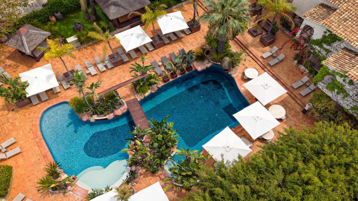 Una vista aérea de una piscina con mesas y sillas. en SWISS MORAIRA HOTEL & SPA - Adults only, en Moraira