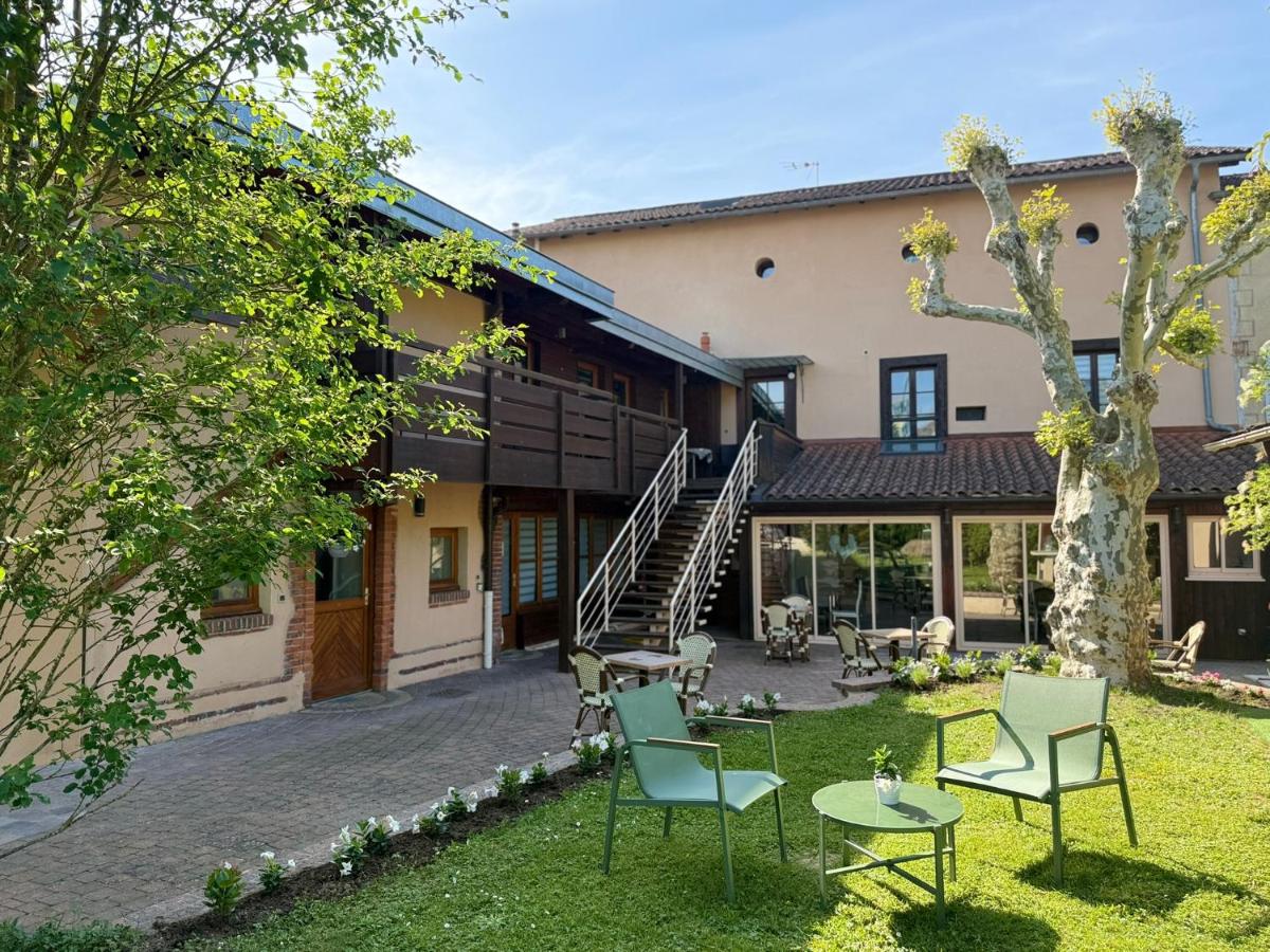 une vue extérieure d'une maison avec des chaises et une table dans l'établissement Hôtel Au Coq Dort Spa, à Châtillon-sur-Chalaronne