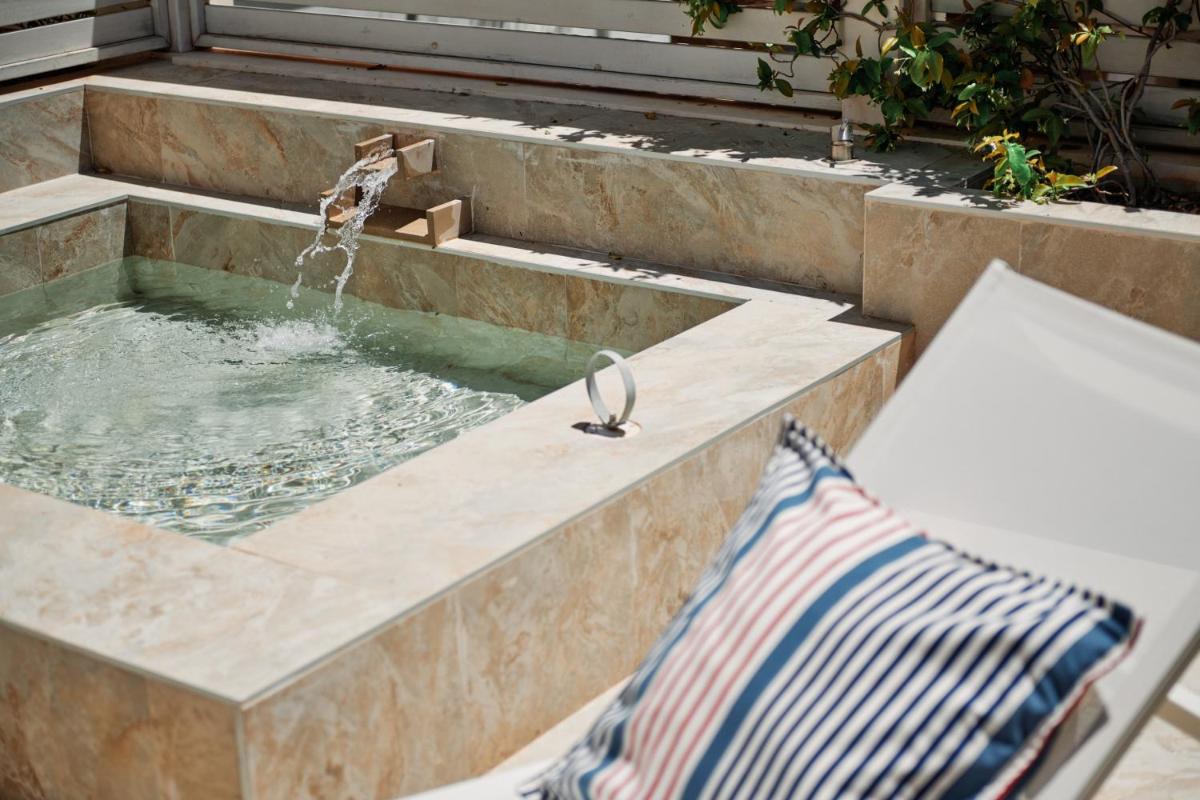 una piscina de agua con un grifo y un banco en Hotel Honucai, en Colonia de Sant Jordi 111 fotos más
