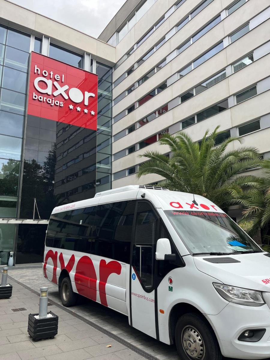 un autobús blanco estacionado frente a un edificio en Axor Feria, en Madrid
