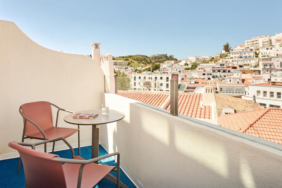 uma varanda com mesa e cadeiras e vista em Hotel Indigo Albufeira by IHG em Albufeira mais 78 fotografias