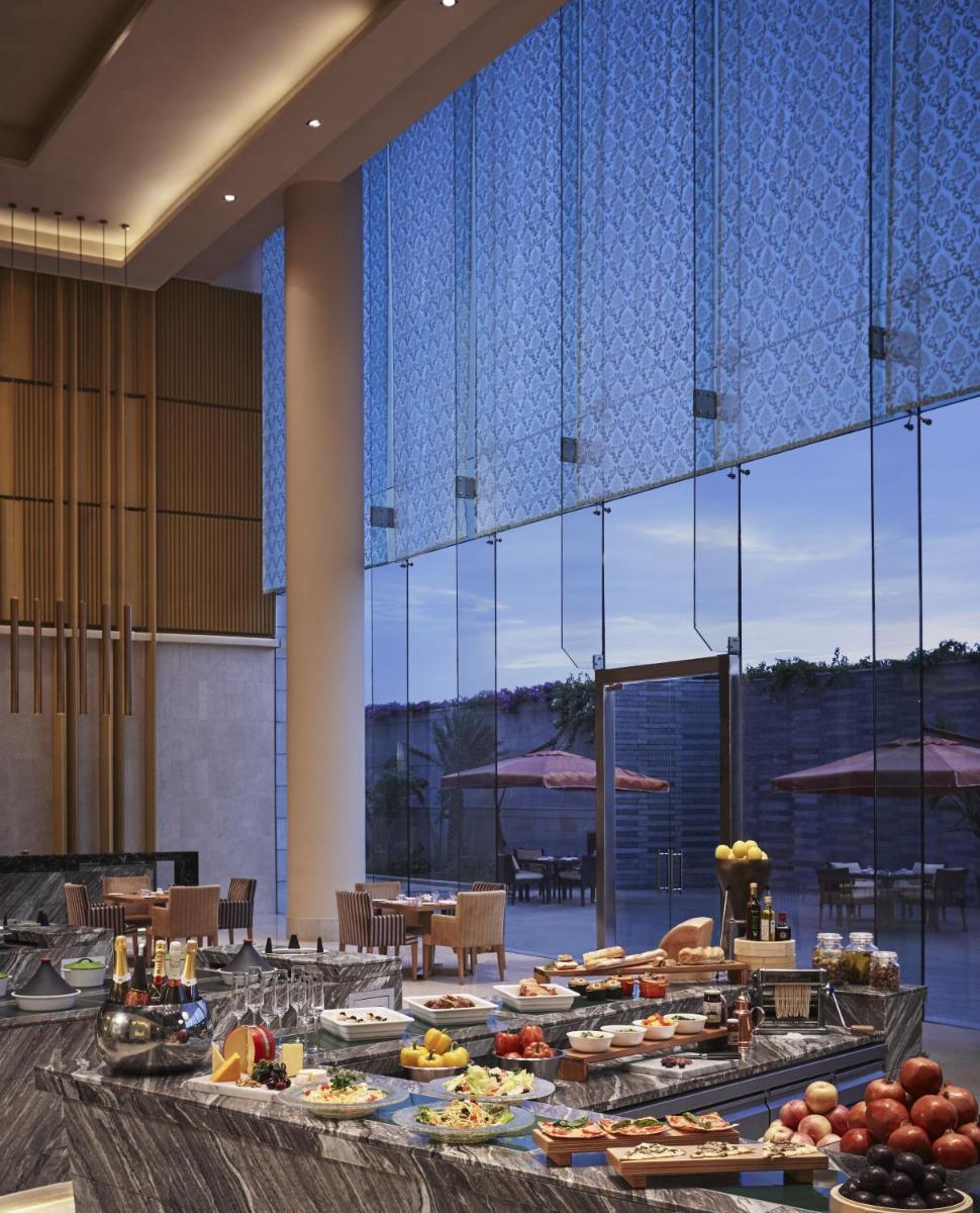 a buffet line with plates of food in a restaurant at Taj Bangalore in Devanahalli-Bangalore