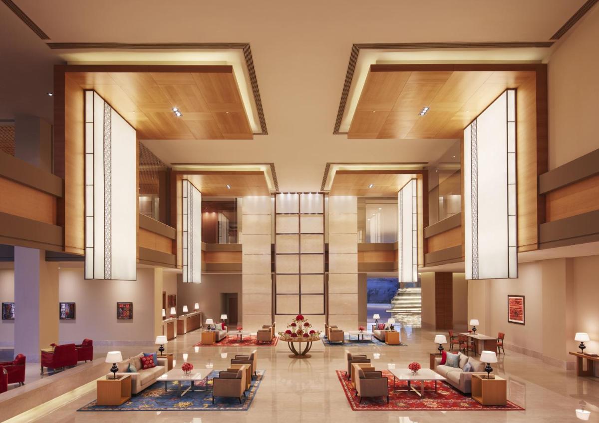 a lobby of a hotel with chairs and tables at Taj Bangalore in Devanahalli-Bangalore