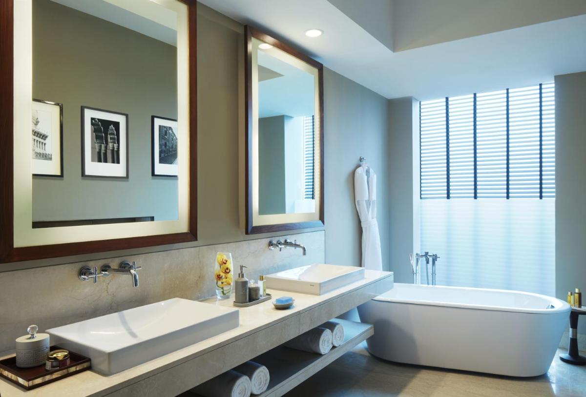 a bathroom with two sinks and a bath tub at Taj Bangalore in Devanahalli-Bangalore
