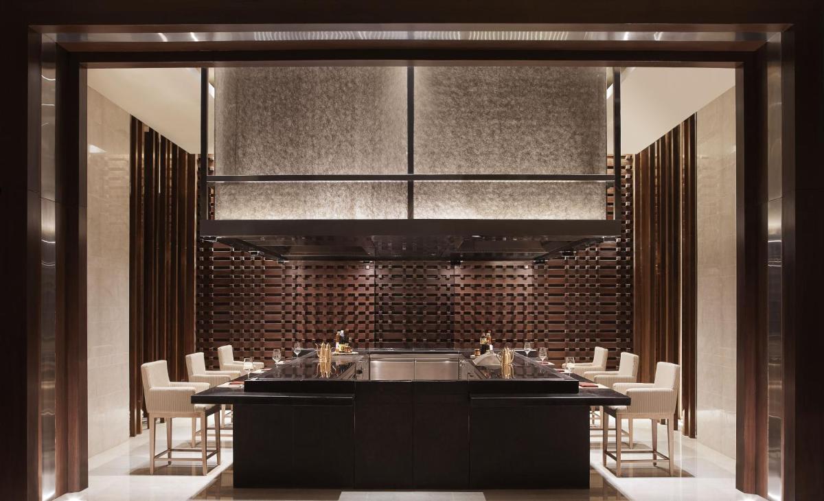 a kitchen with a sink and a bunch of chairs at Taj Bangalore in Devanahalli-Bangalore