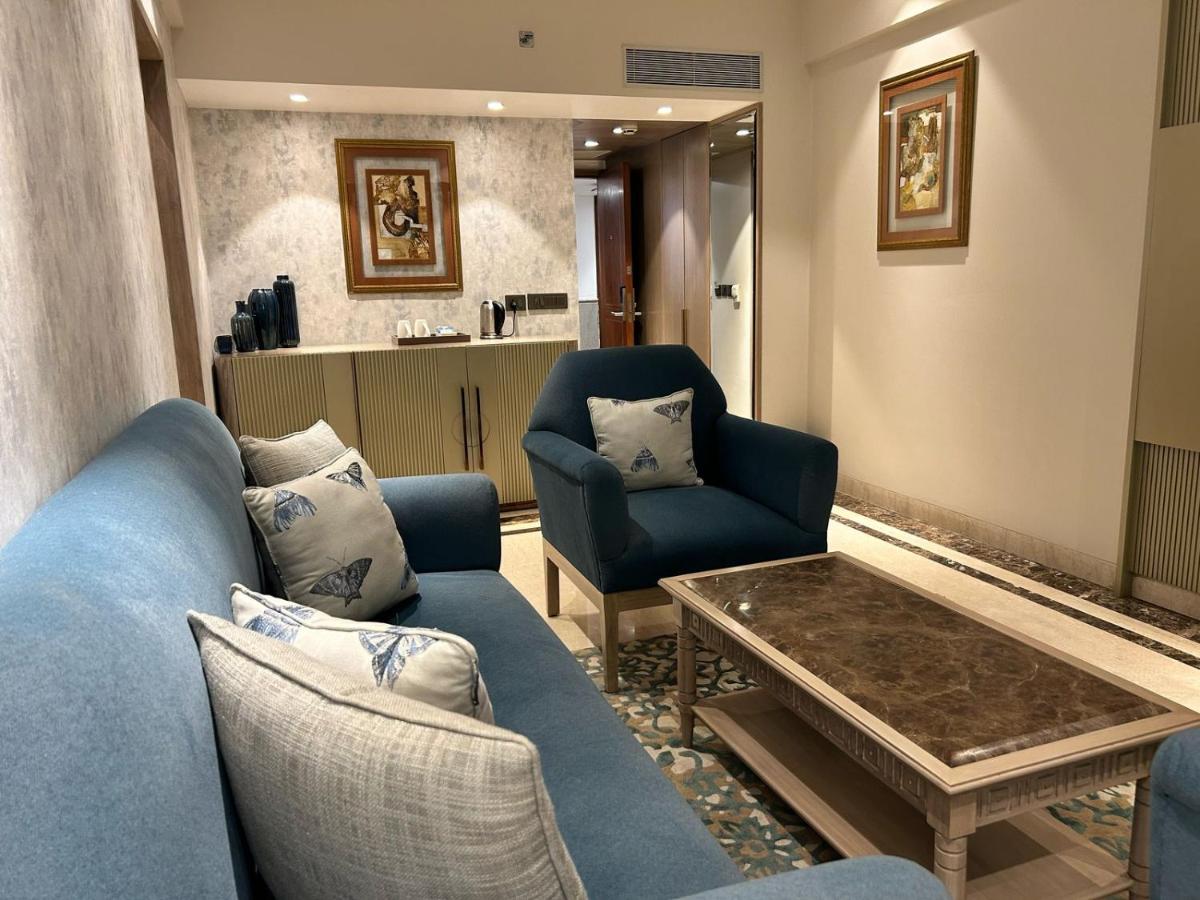 a living room with blue couches and a coffee table at Jaypee Siddharth in New Delhi a living room with blue couches and a coffee table at Jaypee Siddharth in New Delhi