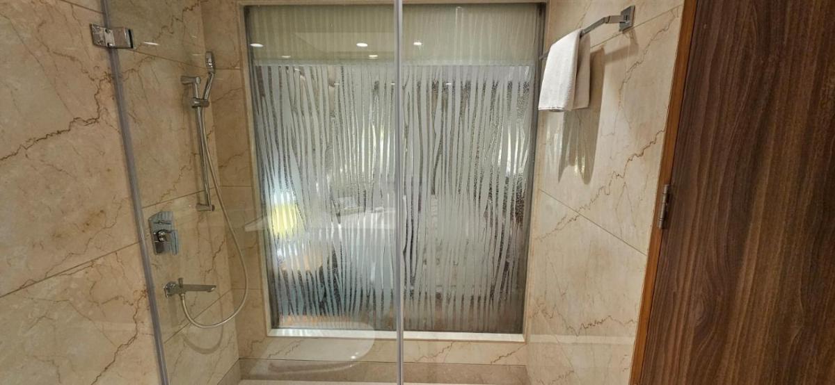 a shower with a glass door in a bathroom at Jaypee Siddharth in New Delhi a shower with a glass door in a bathroom at Jaypee Siddharth in New Delhi