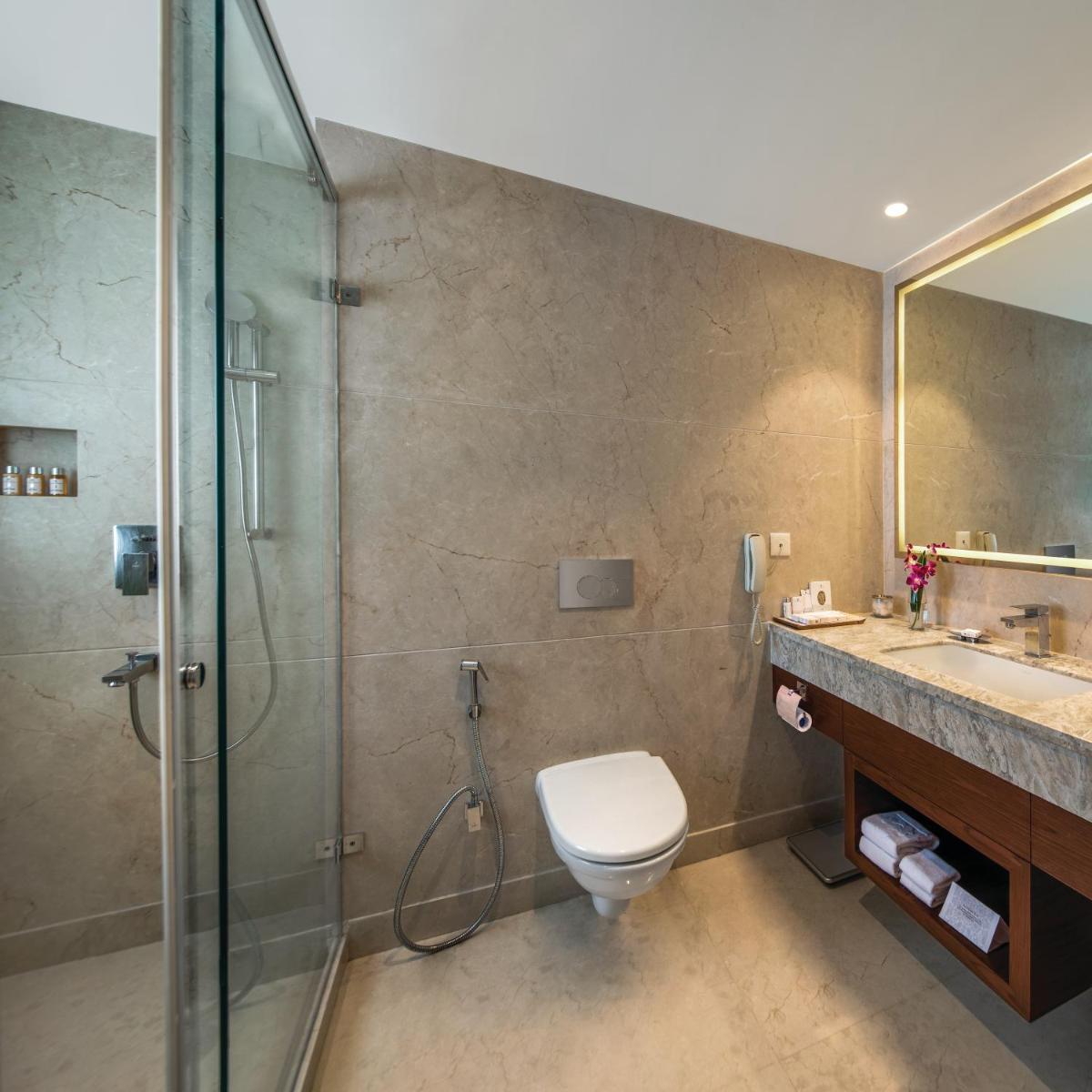 a bathroom with a shower and a toilet and a sink at Jaypee Siddharth in New Delhi a bathroom with a shower and a toilet and a sink at Jaypee Siddharth in New Delhi
