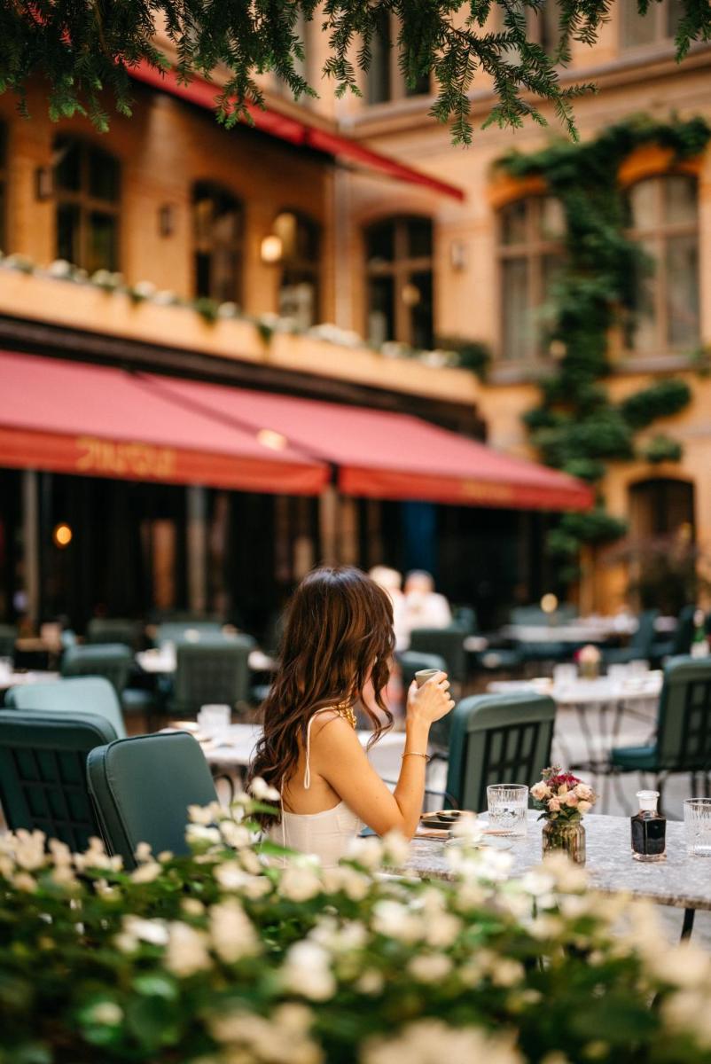 eine Frau, die an einem Tisch in einem Restaurant sitzt in der Unterkunft TORTUE Hamburg in Hamburg eine Frau, die an einem Tisch in einem Restaurant sitzt in der Unterkunft TORTUE Hamburg in Hamburg