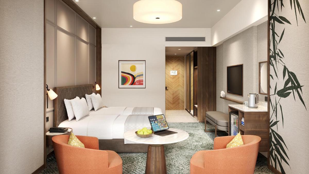 a hotel room with a bed and a table and chairs at Holiday Inn New Delhi Mayur Vihar Noida by IHG in New Delhi a hotel room with a bed and a table and chairs at Holiday Inn New Delhi Mayur Vihar Noida by IHG in New Delhi
