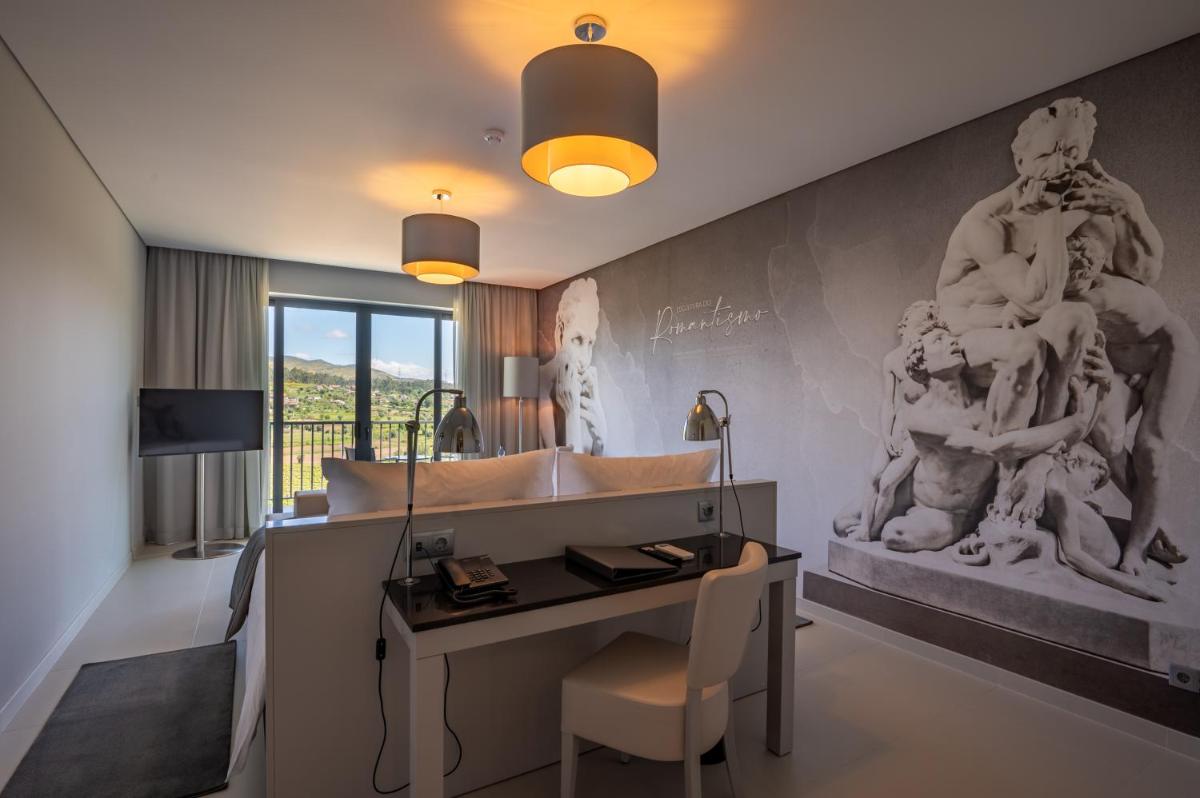um quarto com uma escrivaninha com uma escultura na parede em Vila Gale Collection Ponte de Lima em Ponte de Lima