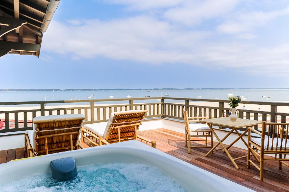 une baignoire sur une terrasse avec des chaises et une table dans l'établissement Residence Les Suites Pereire, à Arcachon