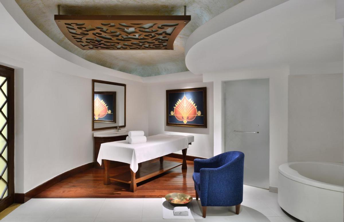 a bathroom with a white table and a blue chair at Le Meridien New Delhi in New Delhi a bathroom with a white table and a blue chair at Le Meridien New Delhi in New Delhi