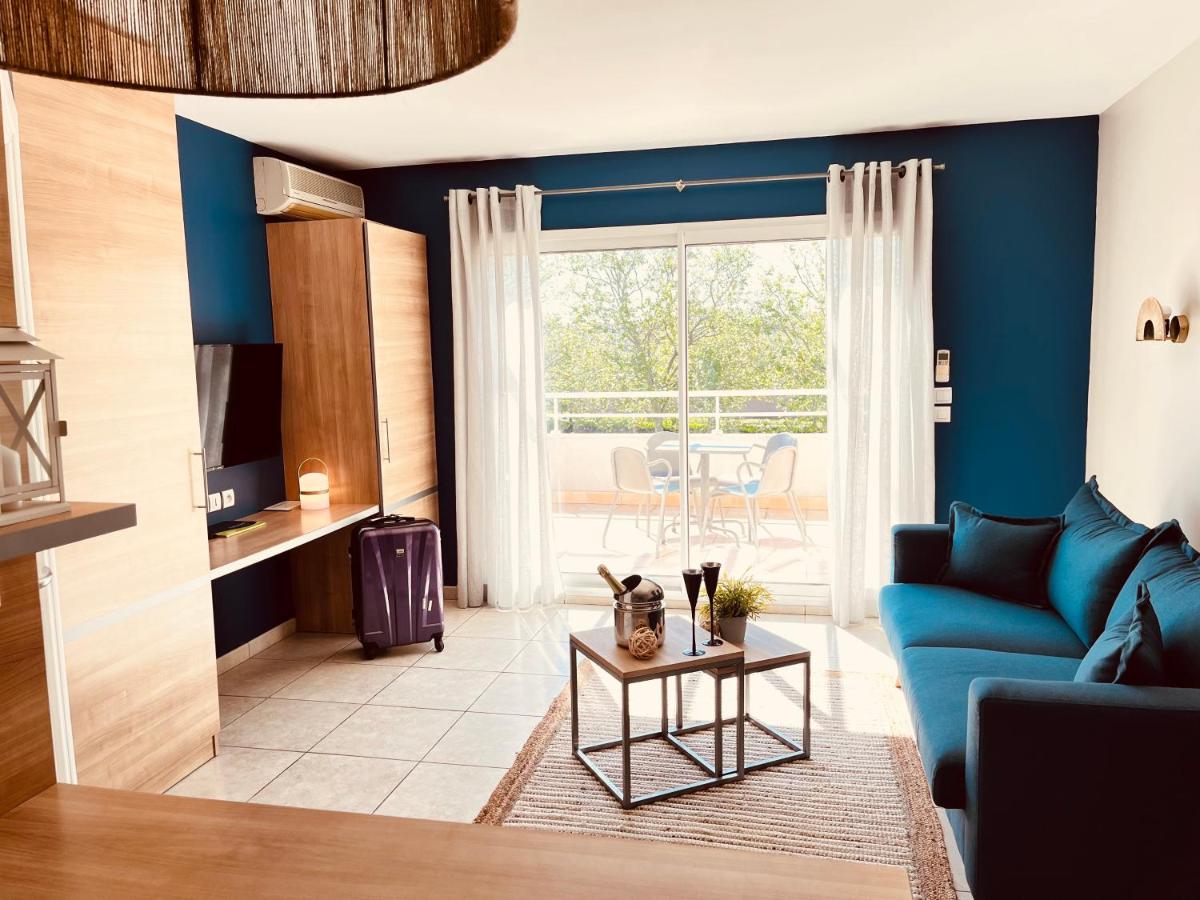 un salon avec des murs bleus et un canapé bleu dans l'établissement Résidence Hôtelière Natureva & Spa, au Cap d'Agde