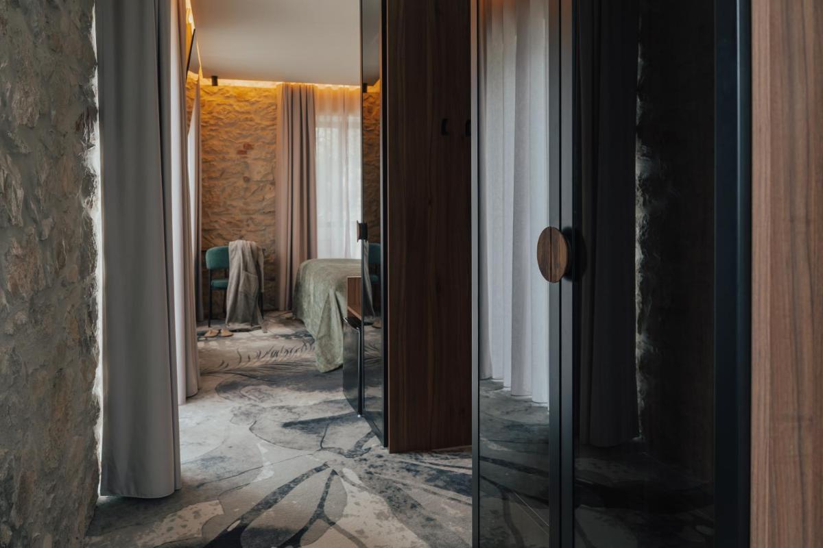 um corredor de um quarto de hotel com um espelho em Hotel Leiriartem by Grupo Quinta dos Lagos em Leiria