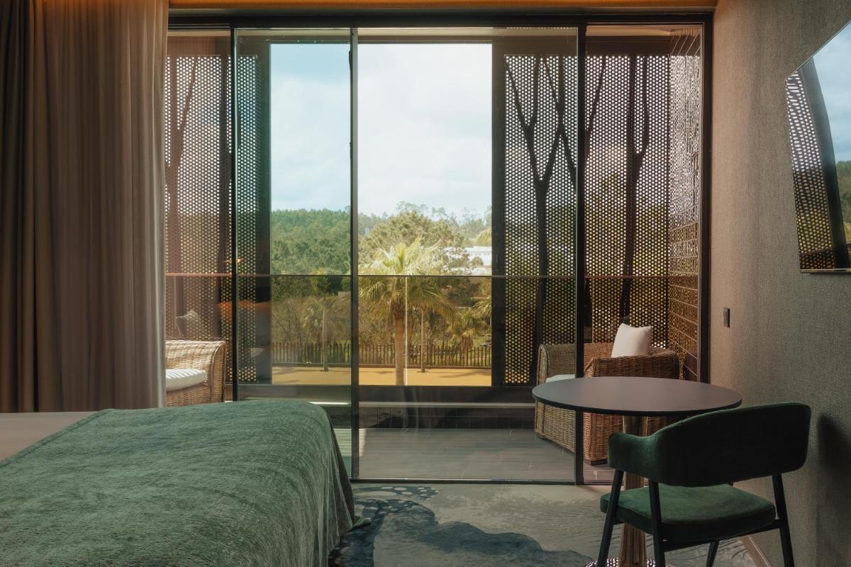 um quarto com uma cama, uma mesa e uma grande janela em Hotel Leiriartem by Grupo Quinta dos Lagos em Leiria mais 112 fotografias