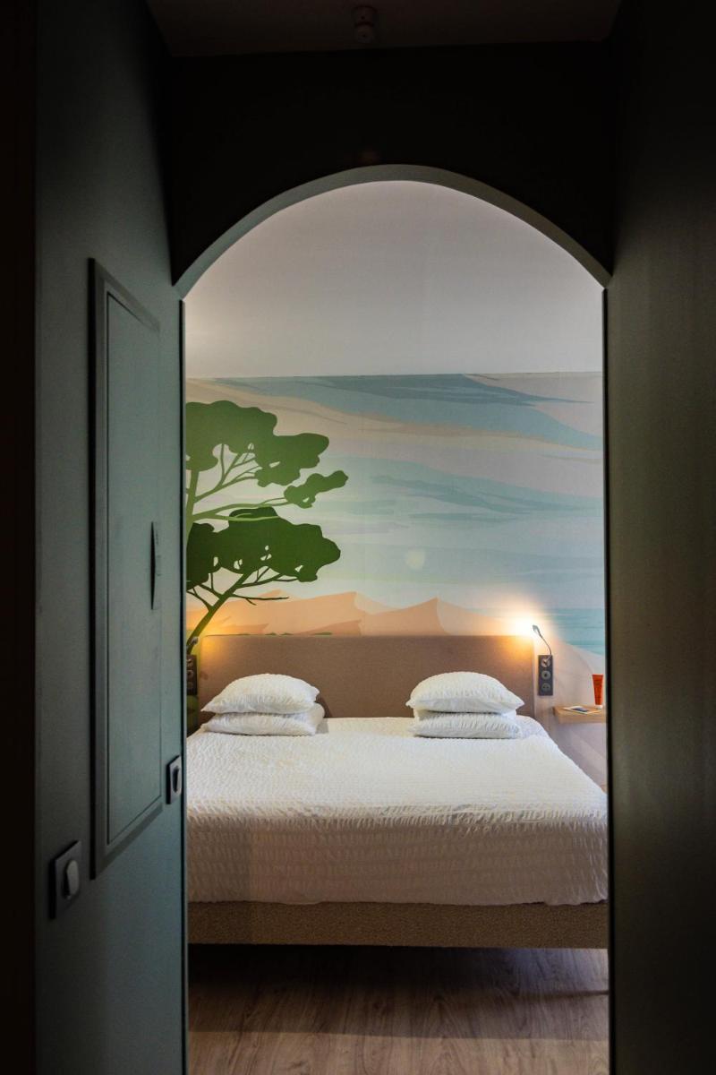 une chambre avec un lit et un tableau au mur dans l'établissement Résidence Hôtelière Natureva & Spa, au Cap d'Agde 68 autres photos
