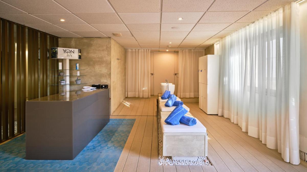 Un vestíbulo con una hilera de almohadas azules en un banco. en Fénix Torremolinos - Adults Only Recommended, en Torremolinos