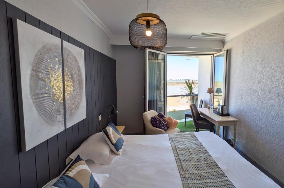 une chambre avec un lit et une vue sur l'océan dans l'établissement Hôtel de La Marée - Face à l'océan - Ile de Ré, à Rivedoux-Plage