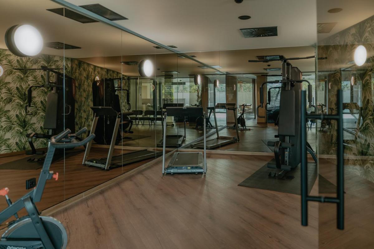 um ginásio com espelhos e equipamento de exercício numa sala em Hotel Leiriartem by Grupo Quinta dos Lagos em Leiria