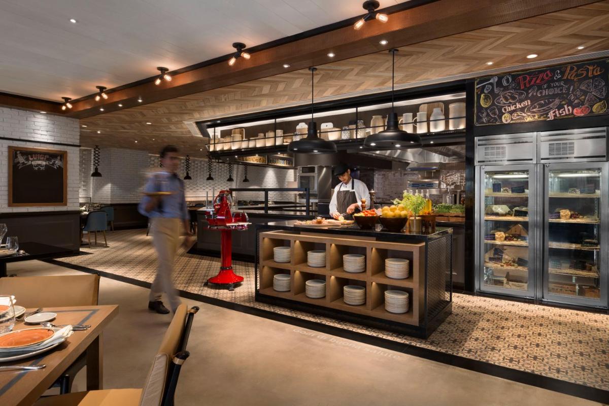 a restaurant with two people standing in a kitchen at Shangri-La Eros New Delhi in New Delhi a restaurant with two people standing in a kitchen at Shangri-La Eros New Delhi in New Delhi