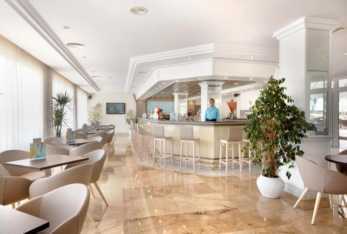 Un restaurante con barra, mesas y sillas. en Grupotel Orient, en Playa de Palma